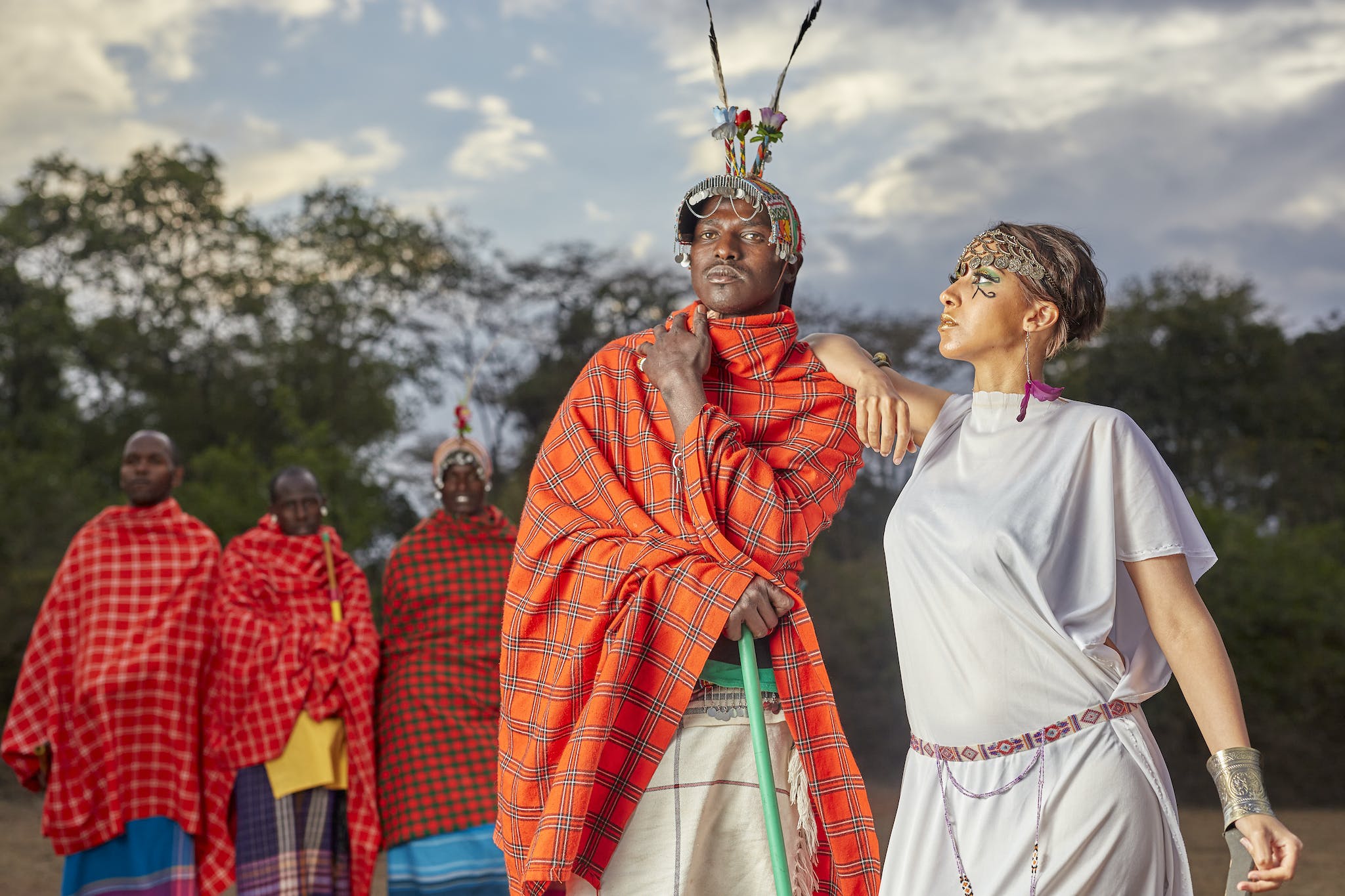 A Woman in White Robe Looking at a Man in Red Traditional Dress